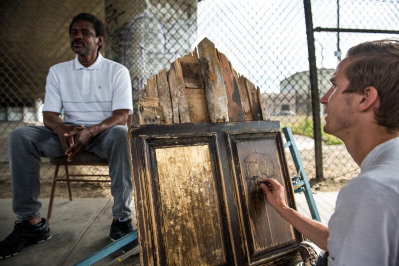 Jason draws Thomas on a recycled objects on skid row los angeles.